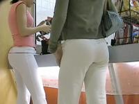 Two girlfriends are in the trading center teasing males with the tight butt jeans view