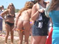 The perverted camera man is voyeuring a beautiful bikini butt of the cute amateur gal