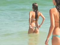 The adorable teens in sexy bikinis are playing with the waves and getting spied on cam