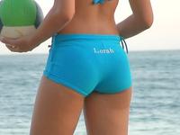The perfectly shaped amateur gal is playing with the ball in sport shorts on the beach